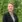 Medarbejder i sort blazer foran grøn natur