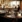 Elegant restaurantbord med vinglas og åbent køkken i baggrunden