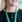 Grøn lanyard med solsikker om halsen på konferencedeltager